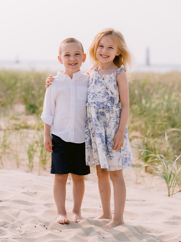 A little girl has her arm around a little boy in Northern Michigan in the summer