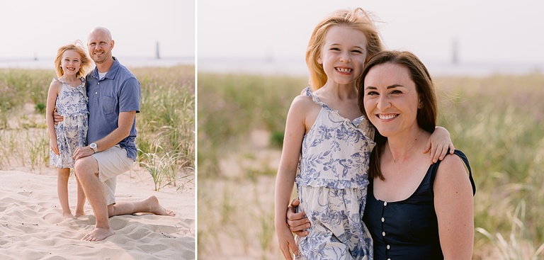 A man kneels in the sand with his daughter and a mother poses with her daughter