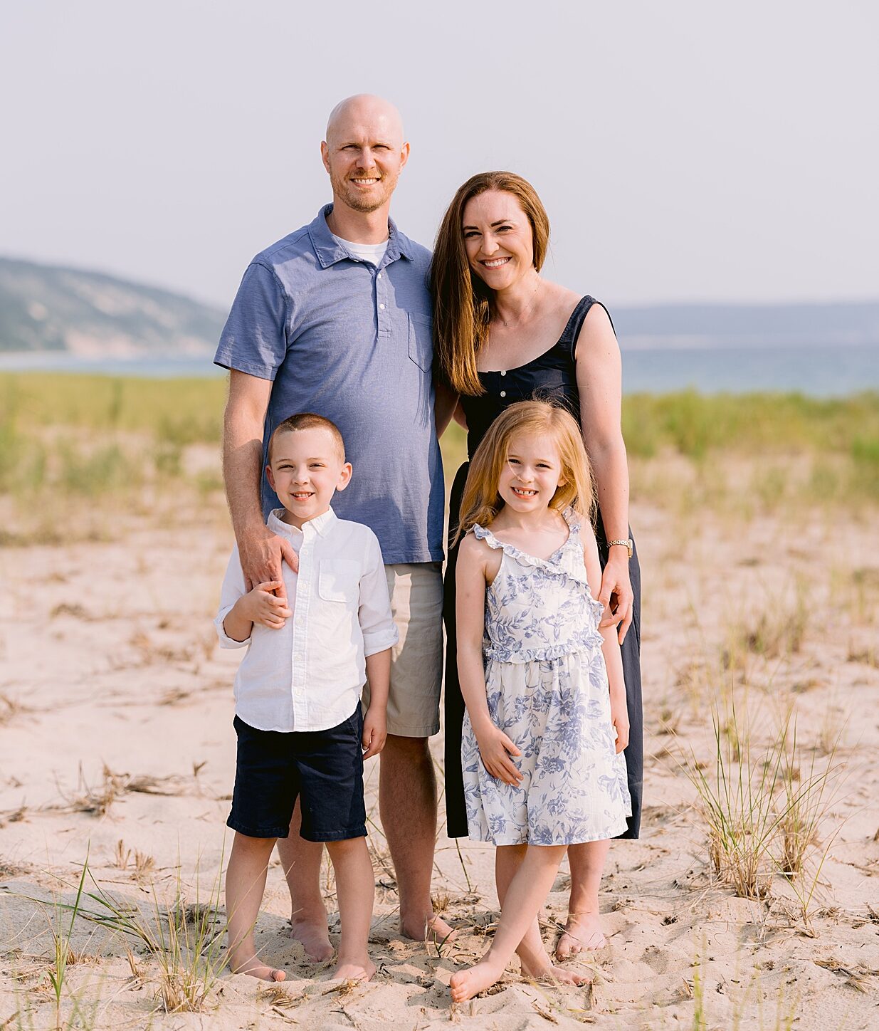 A happy family portrait on a sandy beach on Lake Michigan by Cory Weber