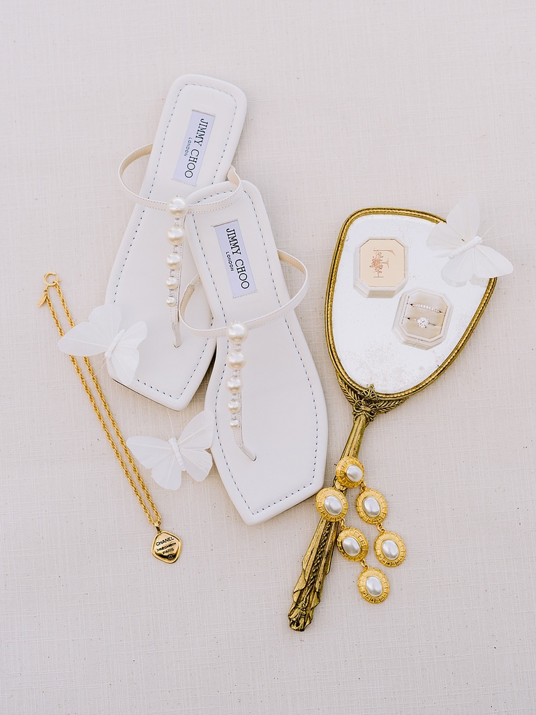 White Jimmy Choo shoes with gold Chanel earrings and a necklace