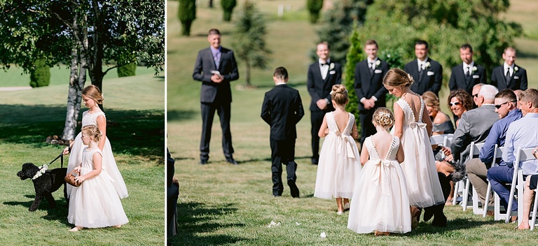 The flower girls, ring bearer, and small black dog walking dow the aisle in Michigan