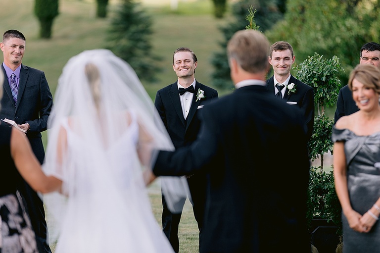 The groom smiling really big as his bride gets closer to him in Ubly, Michigan