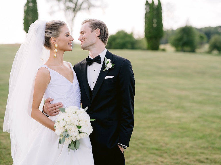 A bride and groom looking and smiling at each other