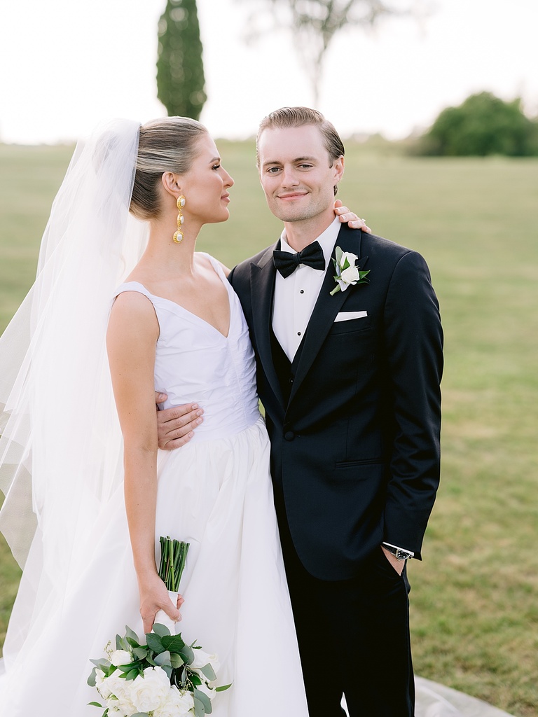 A bride looking at her groom while he looking at the camera in Ubly, Michigan