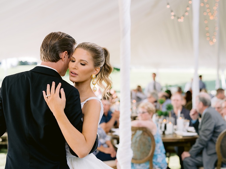 A bride whispering into her grooms ear during their first dance