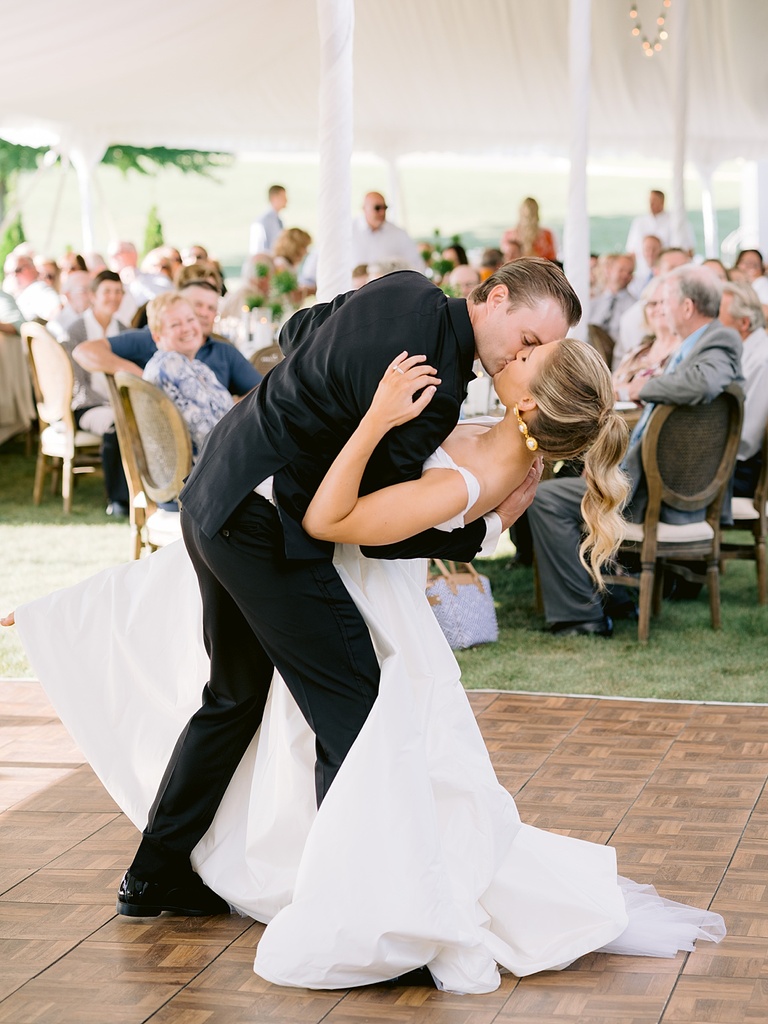 A groom dipping his bride and kissing her at the end of their first dance