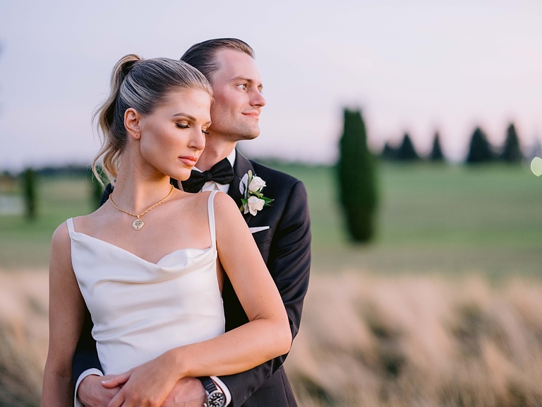 a bride and groom soaking in a few moments together at sunset