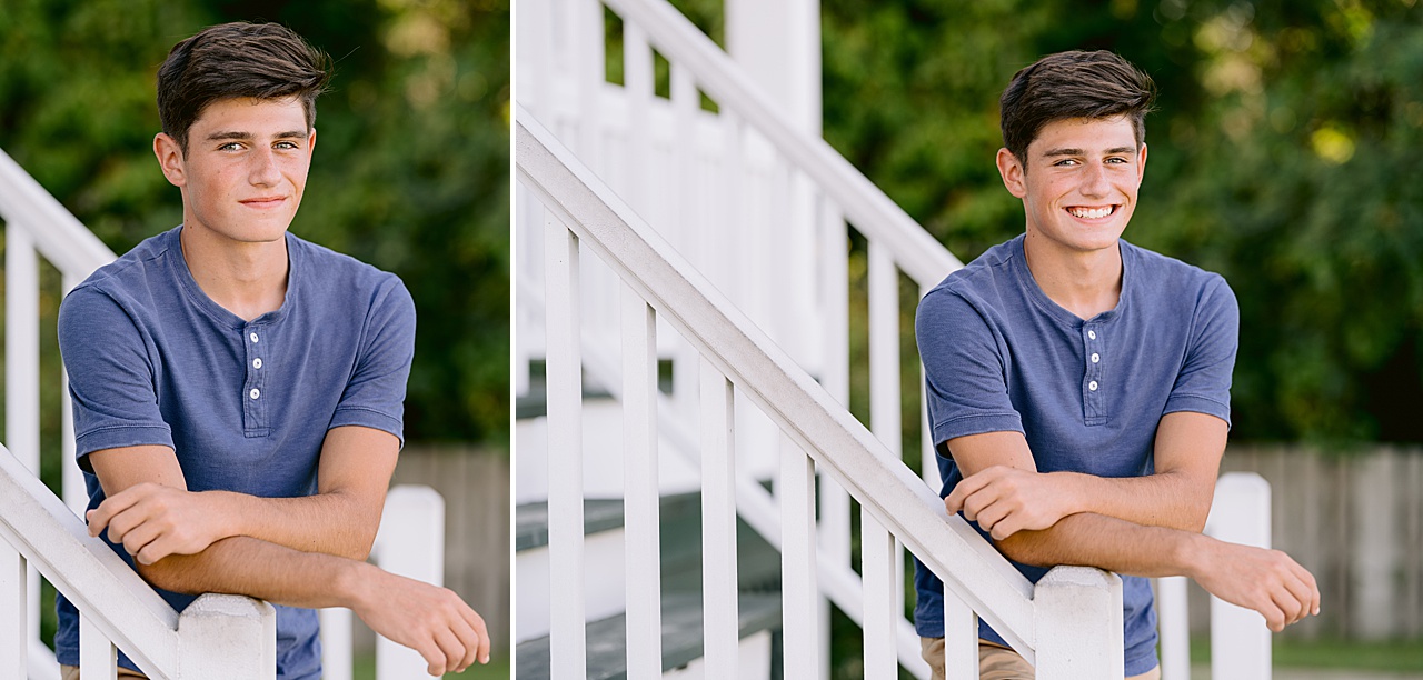 A young man poses for senior portrait photography while leaning against white railing