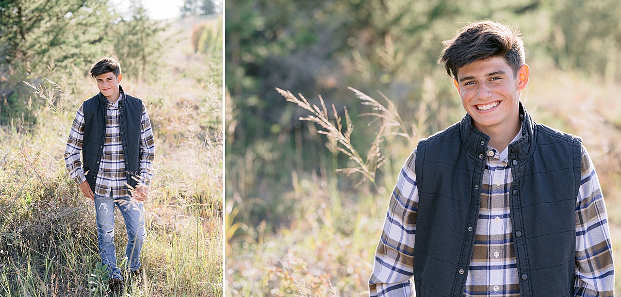 A boy wears a flannel and vest while standing in tall grass in Northern Michigan