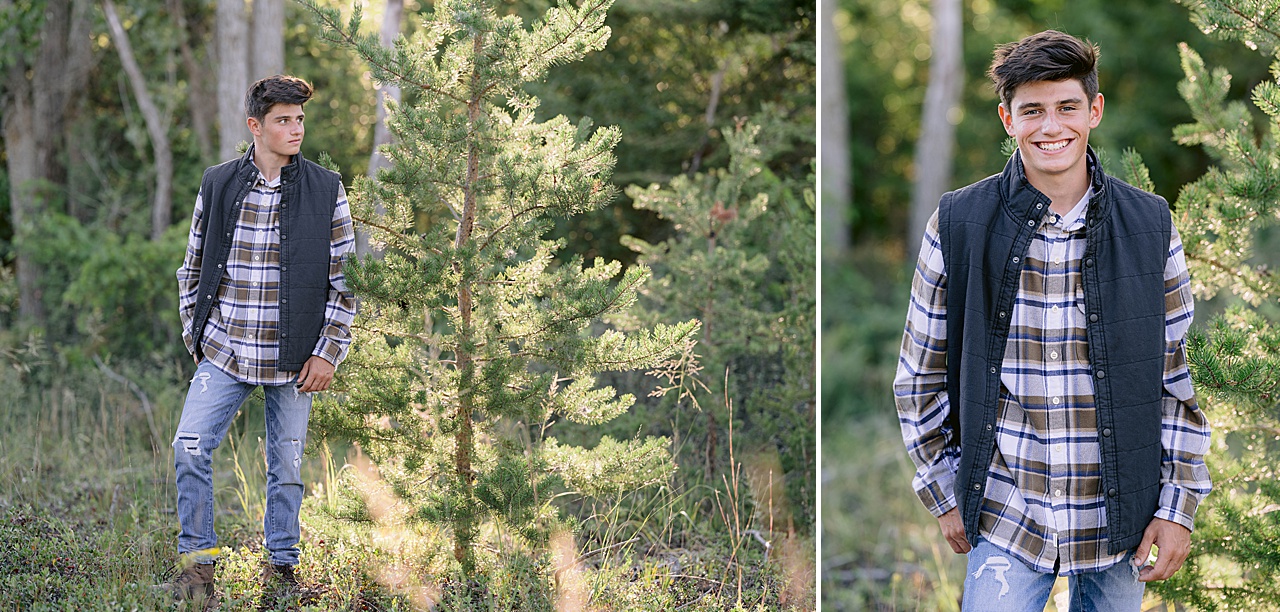 A senior in high school stands in a Northern Michigan forest for senior photos