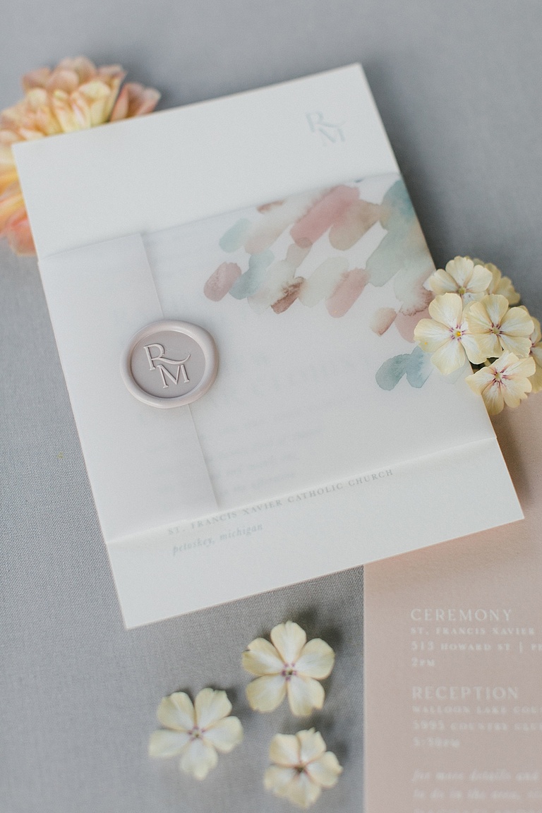 A wedding invitation suite with pastel accents