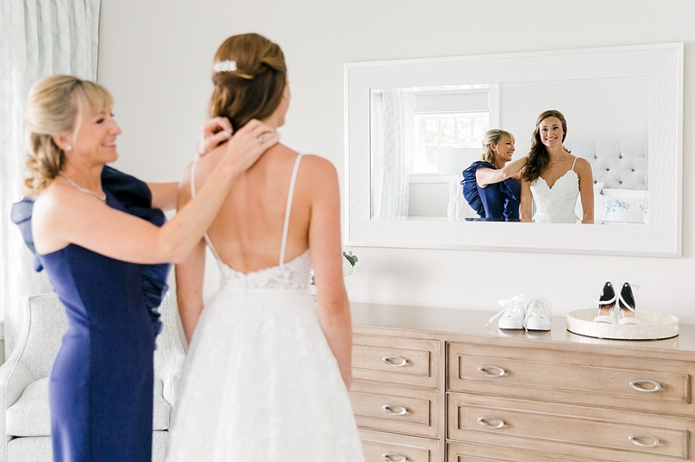 A mother of the bride putting on her daughters necklace on her wedding day in Michigan