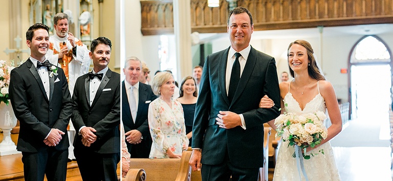 A bride smiling at her groom while walking towards him in Saint Francis Xavier Catholic Church