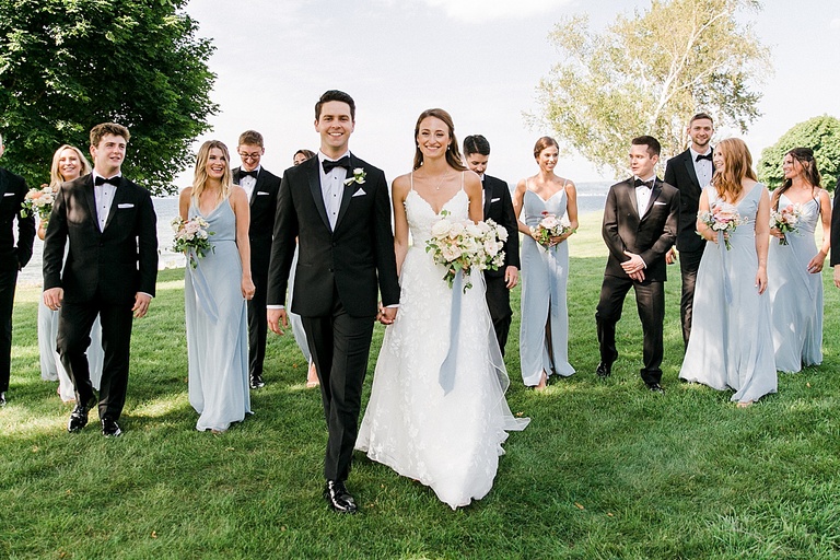 A bride and groom walking and smiling with their wedding party in Northern Michigan