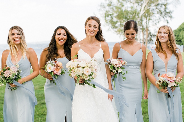 A bride smiling and walking with her bridesmaids in Michigan