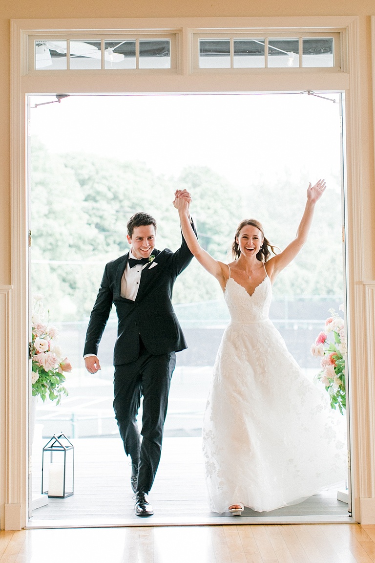 A bride and groom walking into their wedding reception at the Walloon Lake Country Club