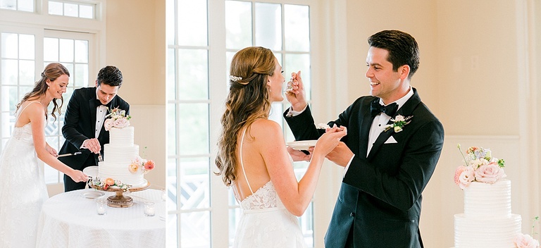 A bride and groom cutting their 3 tier wedding cake decorated with florals at their reception