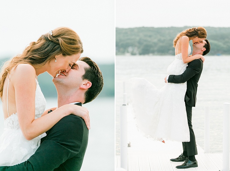 A groom picking up his bride and kissing her on a white dock with Walloon Lake in the background