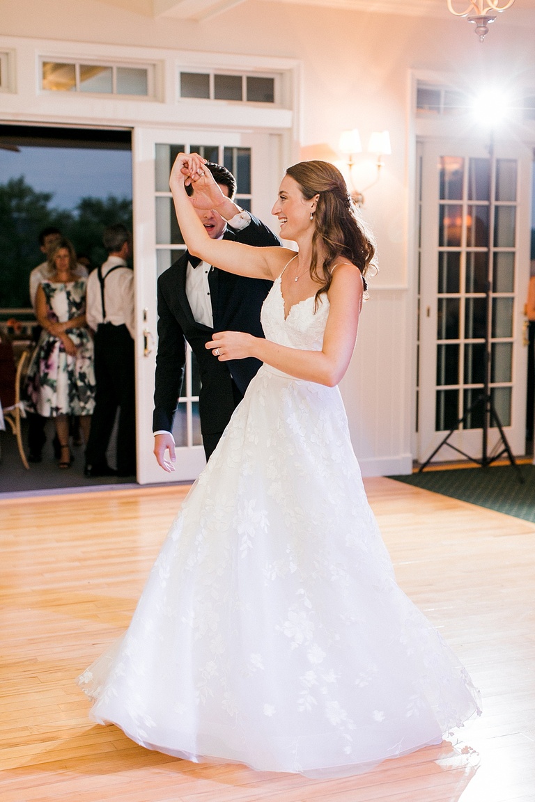 A groom twirling his bride during their first dance