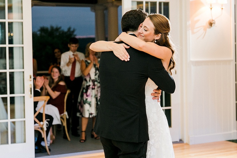 A bride and groom hugging after their first dance together