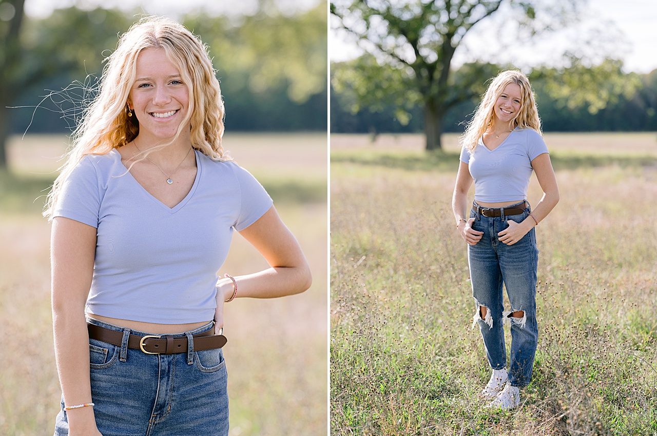 A blonde high school senior girl poses in a field on a summer day