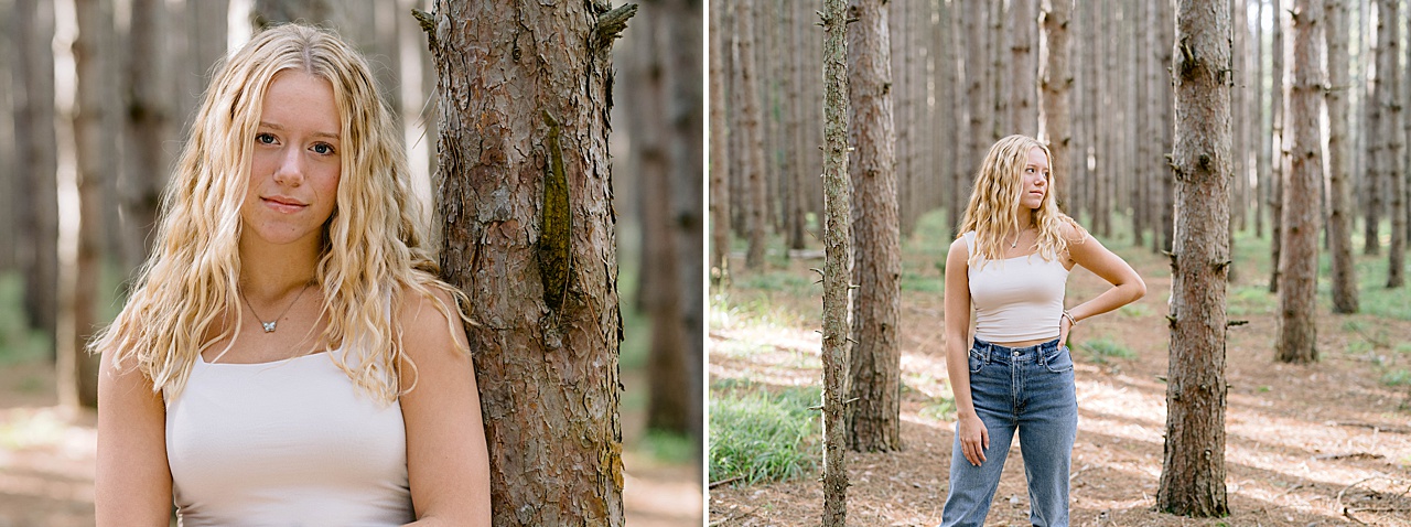 Michigan high school senior portraits next to trees in a wooded forest in summer