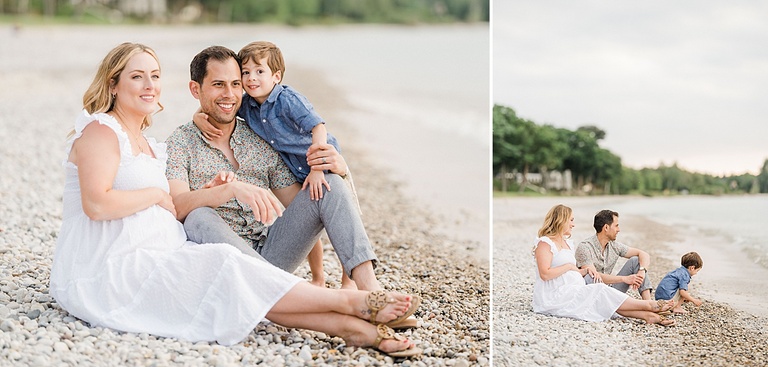 A family sits smiling on a Northern Michigan beach in the summer time during sunset