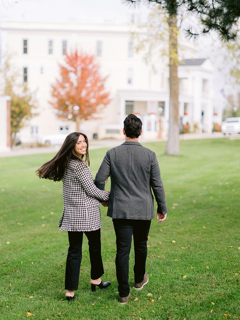 A couple walk through a park holding hands in Petoskey, Michigan