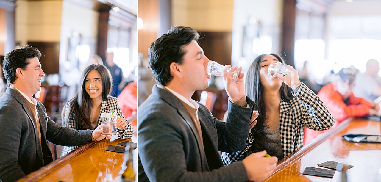 A man and woman smile and laugh while taking tequila shots