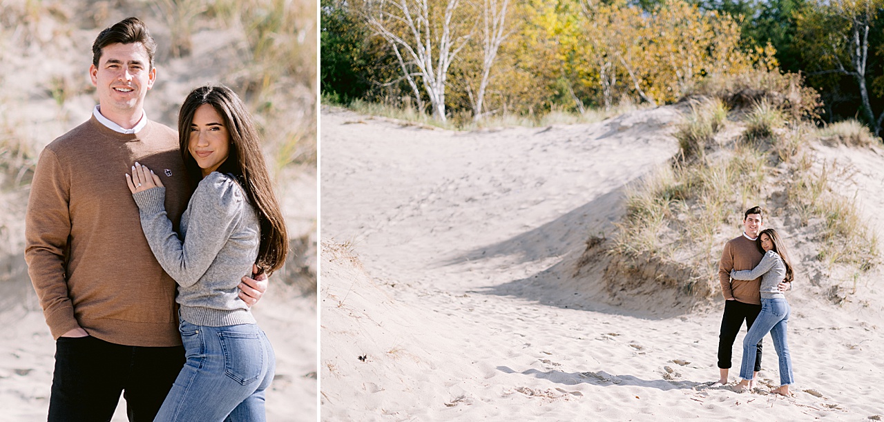 A couple pose on a sandy hill in Northern Michigan in the fall for engagement photos