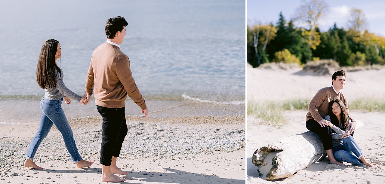 A couple sit beside driftwood next to Lake Michigan in the fall