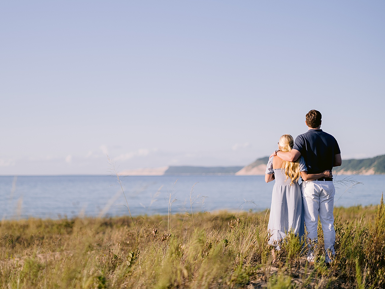 An engaged couple looking at Sleeping Bear Dunes Nation Lakeshore in Honor, Michigan