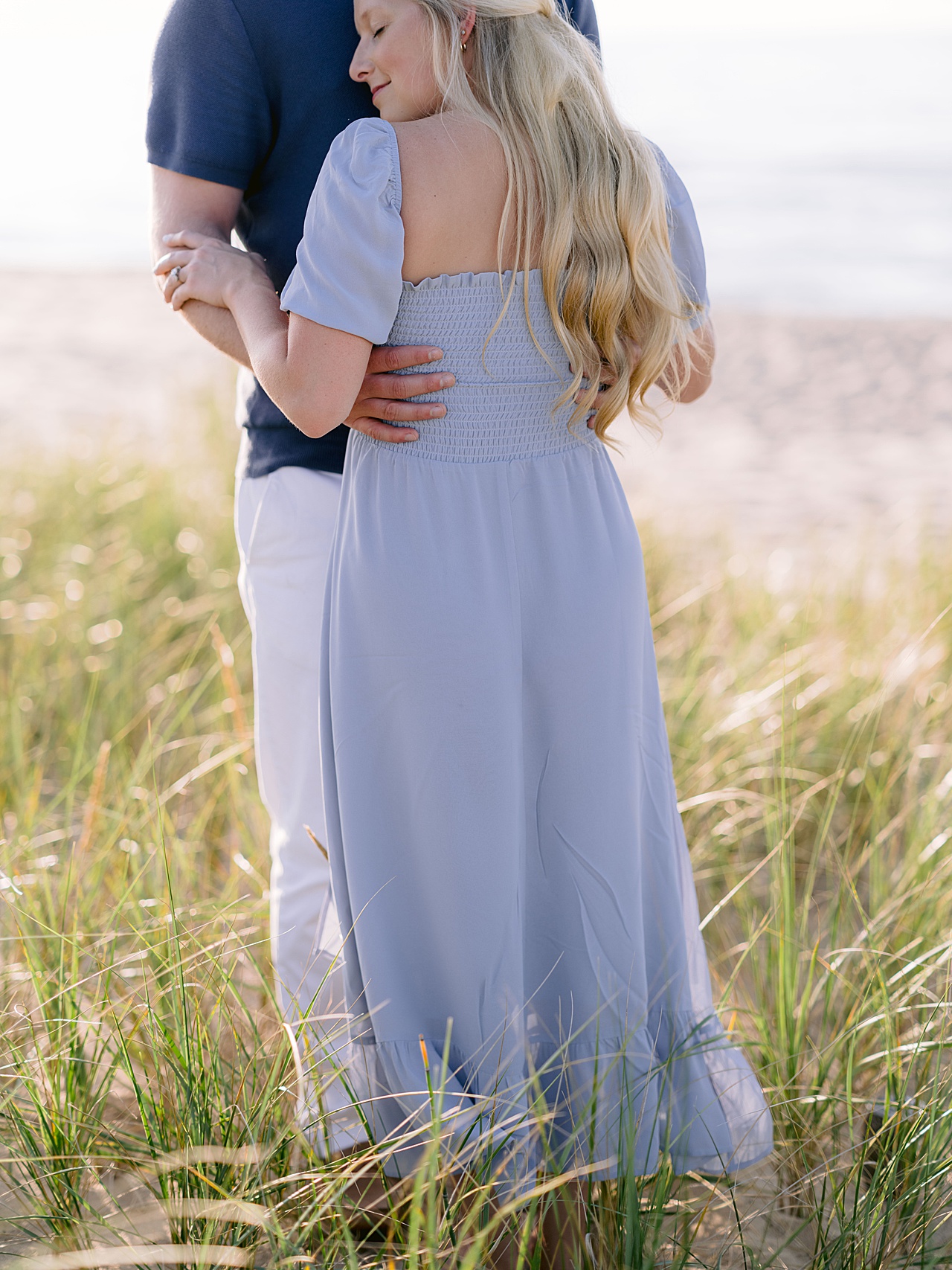 A couple hugging during their engagement session on a warm, sunny, summer evening
