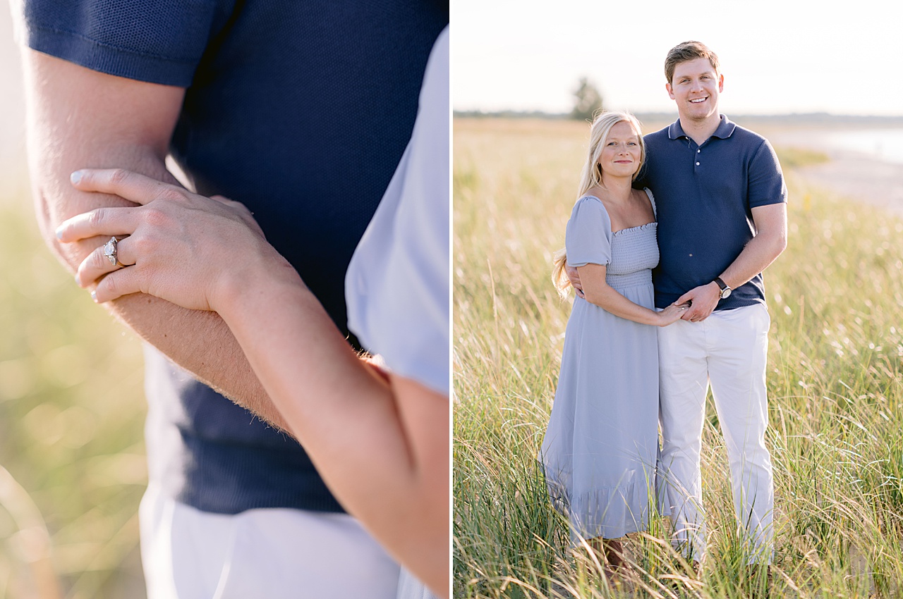 An engaged couple holding hands and smiling for a portrait in tall green dune grass along a lakeshore in Michigan