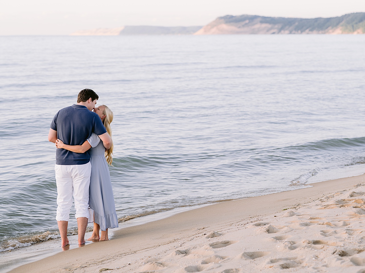 A couple kissing along Lake Michigan during their engagement photography portrait session
