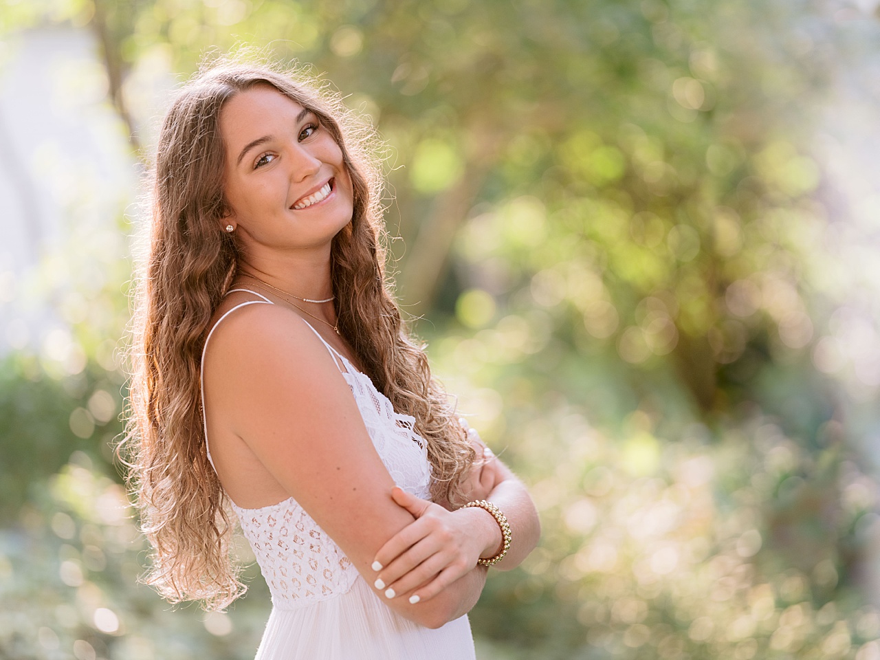 A girl with long brown hair poses for harbor springs senior portraits