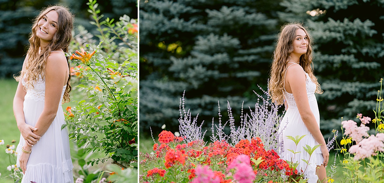 A high school senior girl poses among flowers for portraits in Northern Michigan