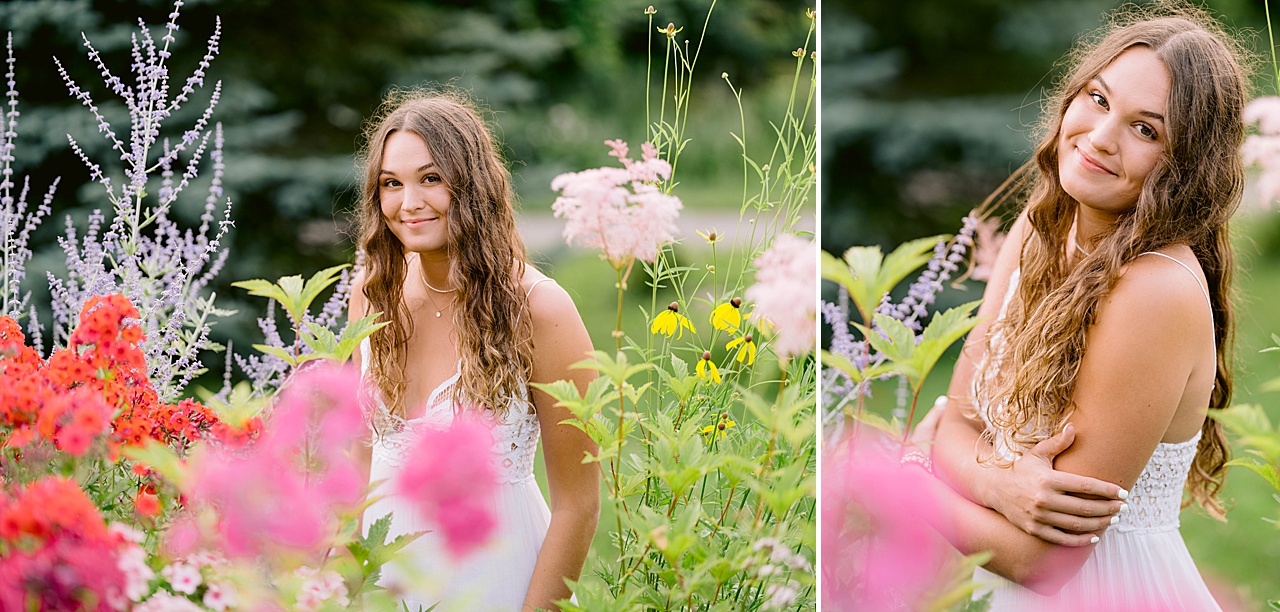 A brunette woman smiles beside flowers for summer senior photos in michigan