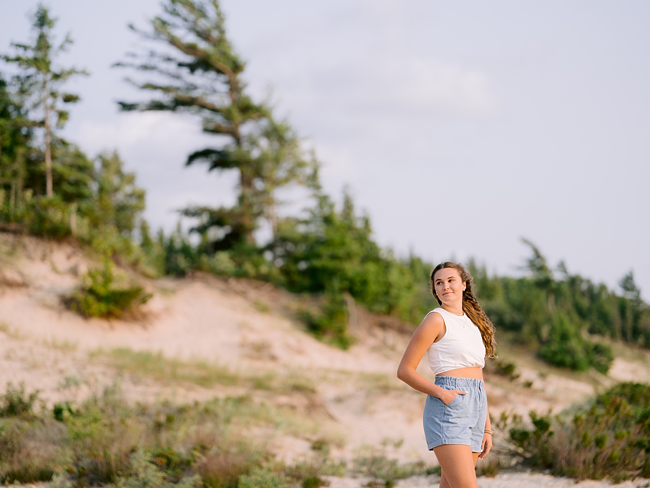 A girl looks into the distance while the wind blows while taking harbor springs senior portraits