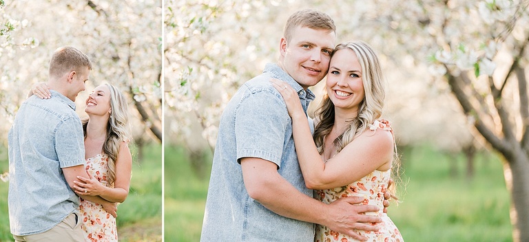 A man and woman look into each other's eyes and smile while they stand in cherry blossoms