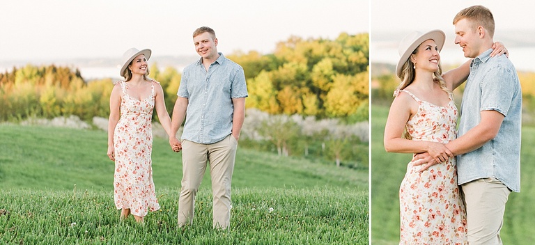 A woman in a white dress smiles at a man in a blue shirt while standing in a grassy field