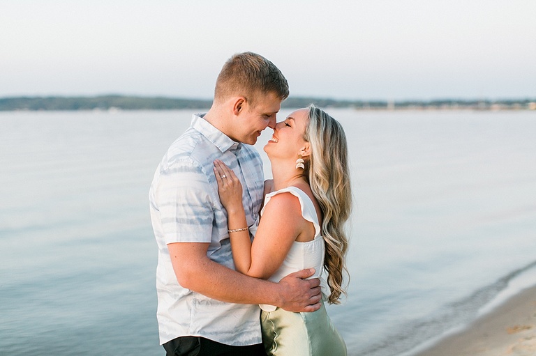 A woman leans into her fiancé while the two of them laugh while looking at each other