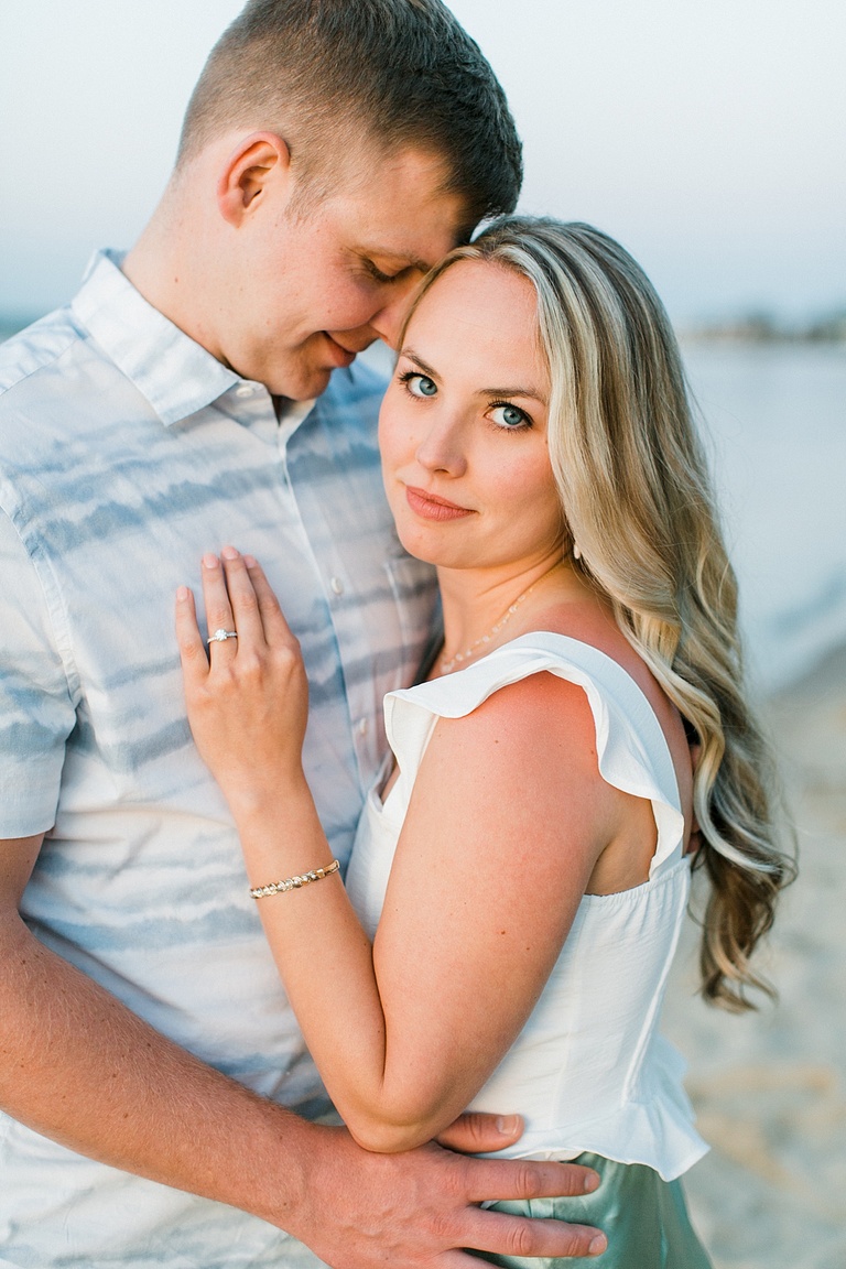 A man leans his forehead against a woman and closes his eyes while she poses for portraits