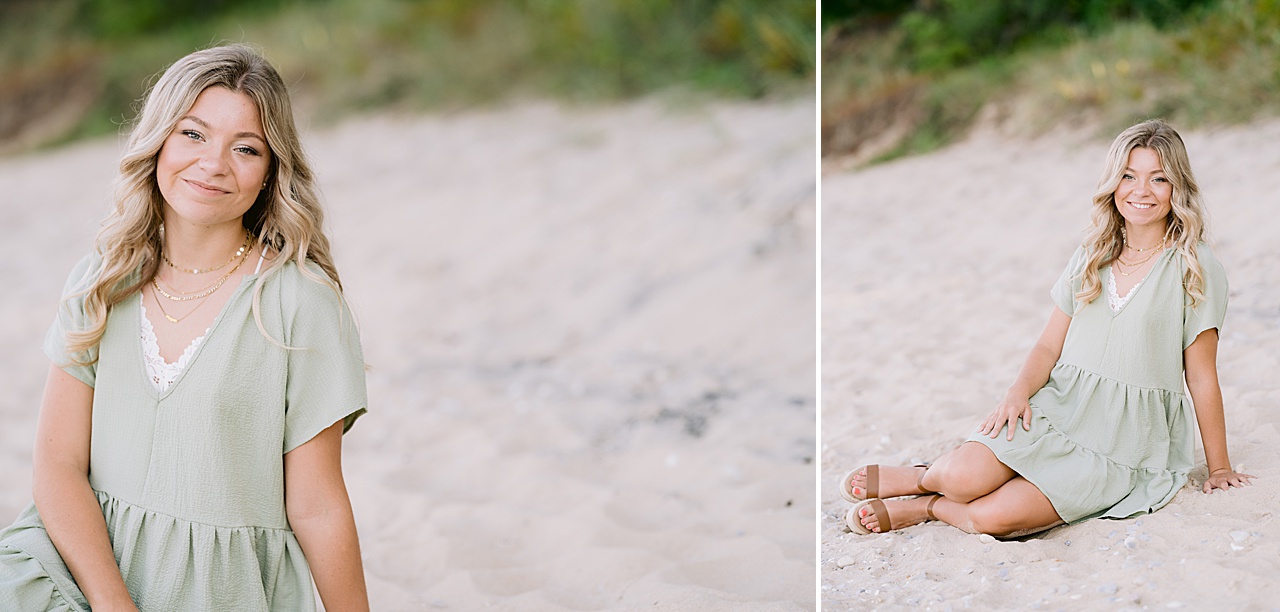 A girl wearing a green dress poses in the sand for senior portraits