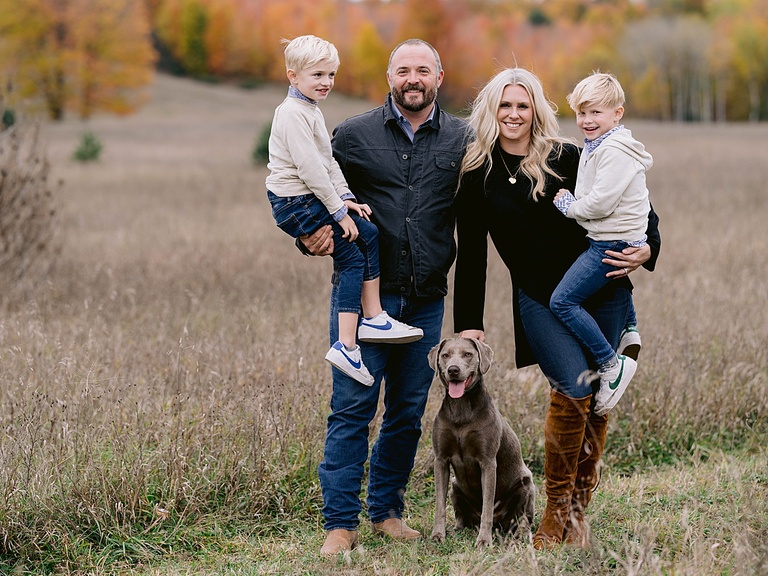 A mother, father, and two sons pose for michigan fall family portraits