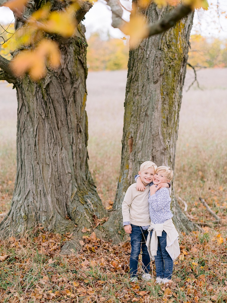 Two little boys pose with their arms around each other for michigan fall family portraits