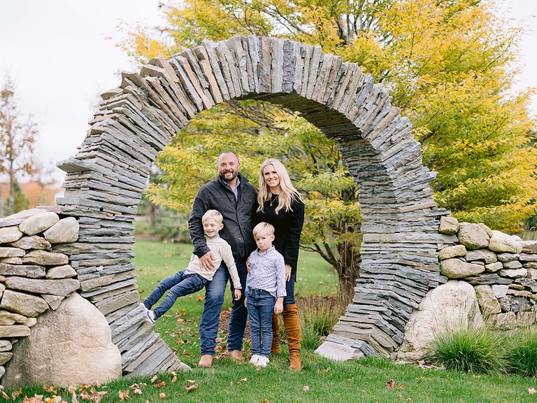 A family of four poses under a beautiful stone archway in Northern Michigan