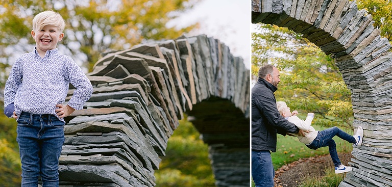 A boy poses next to a stone arch proudly with hands on his hips in Northern Michigan