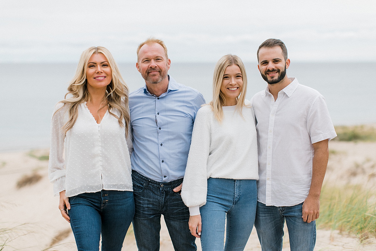 Two couples pose with each other for Northern Michigan family portraits with a lake behind them