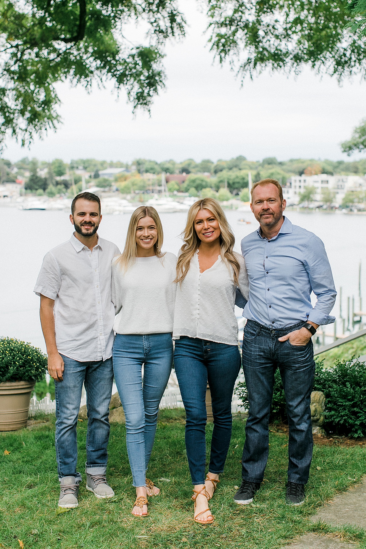 Two couples link arms and smile for portraits while standing in front of a Michigan lake
